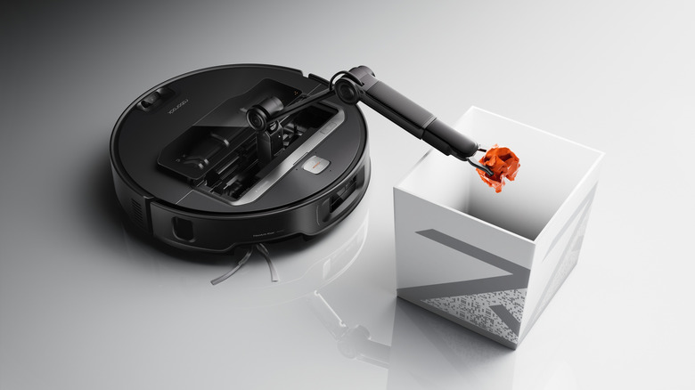 Roborock Saros Z70 using its robotic arm to place trash in a bin