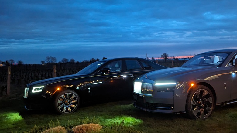 A Rolls Royce Specter and Ghost with overcast skies