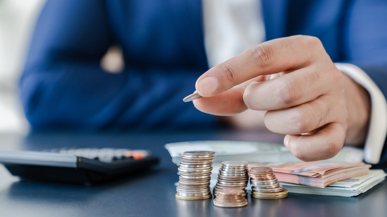 Man counts piles of notes and coins