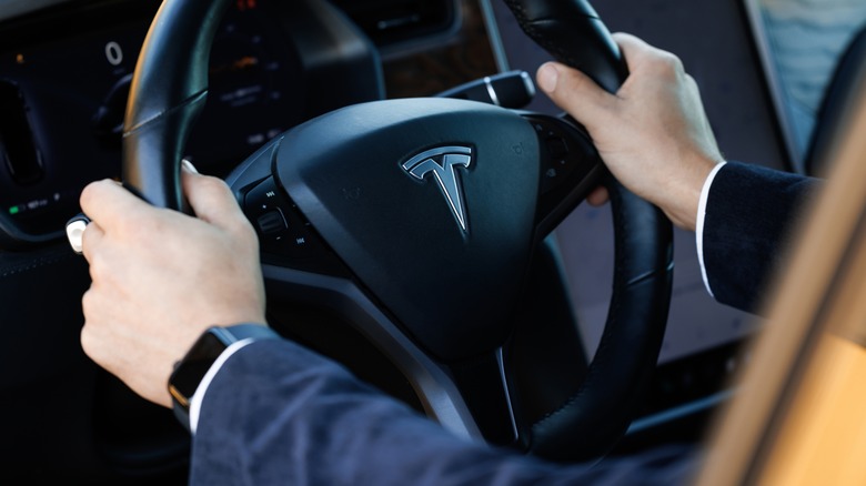 Tesla steering wheel with drivers hands