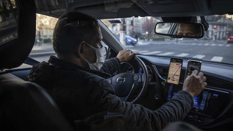 Uber driver checks his phone while driving