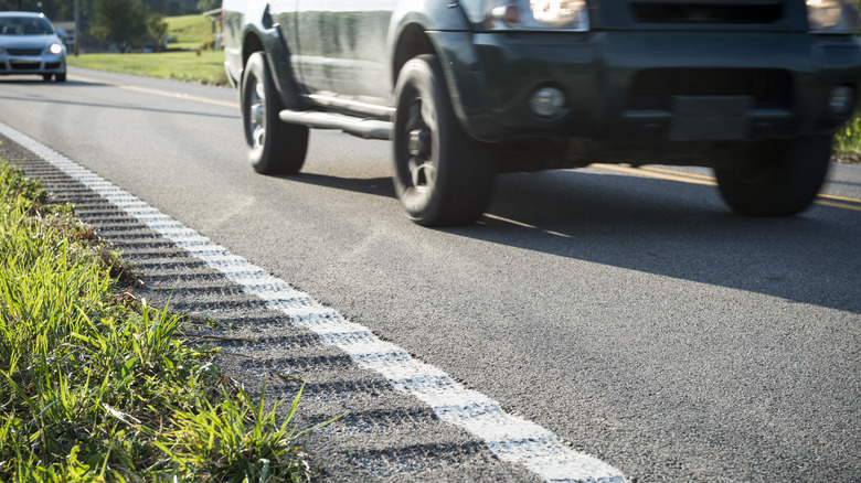 Car drives past rumble strip