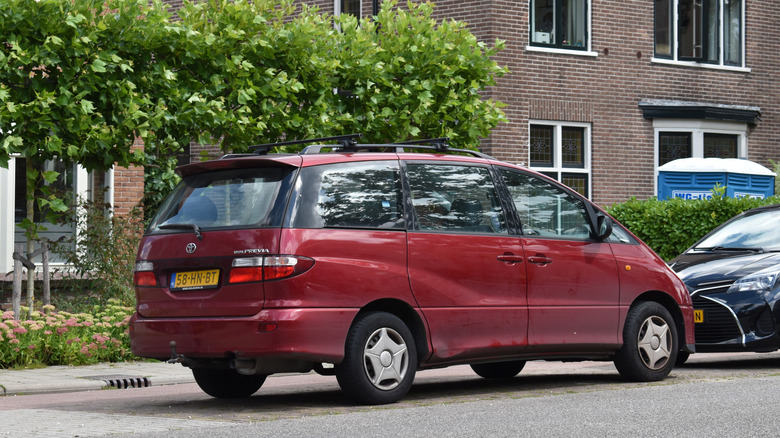 red Toyota Previa parked on city street