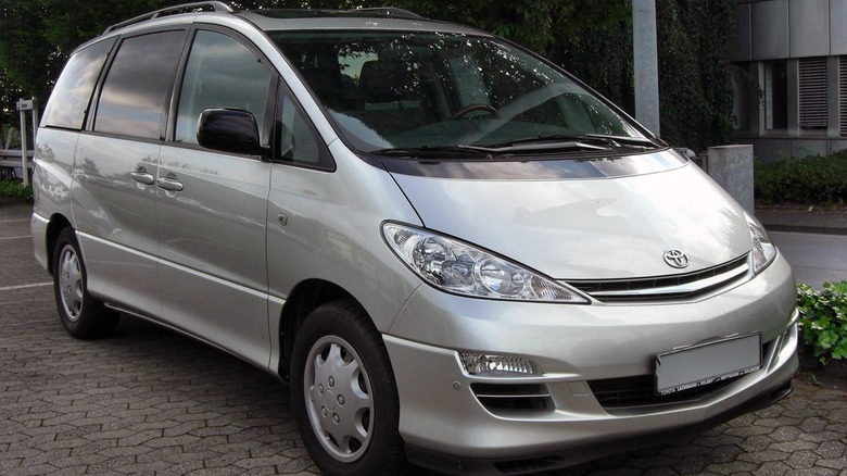 A silver Toyota Previa parked on the sidewalk