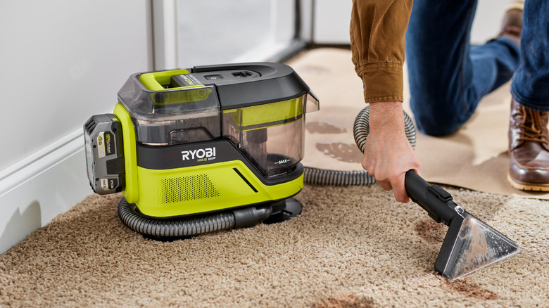 Small vacuum being used on carpet