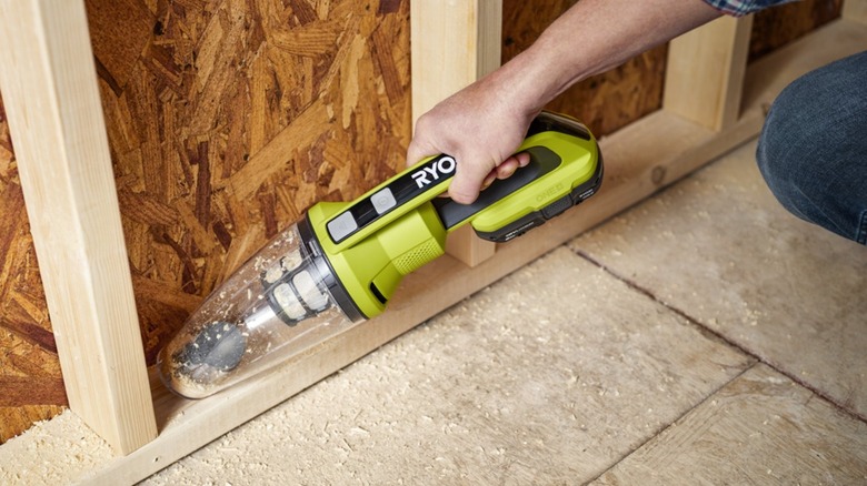 Person using handheld vacuum for sawdust