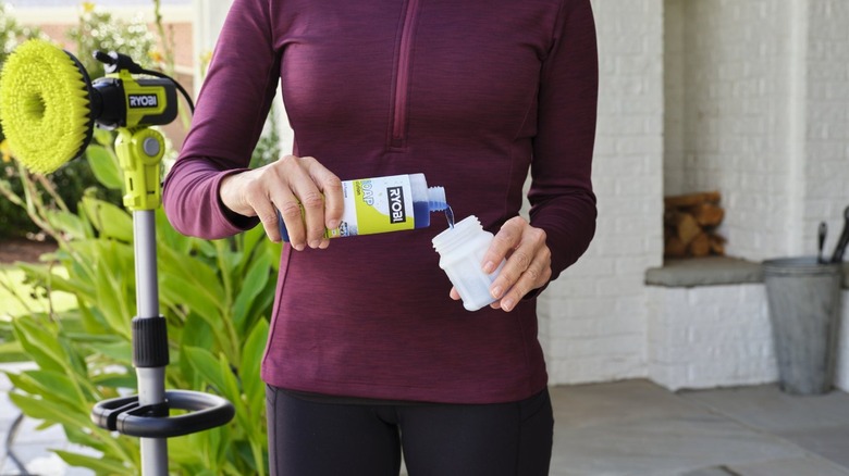 Person pouring soap into container