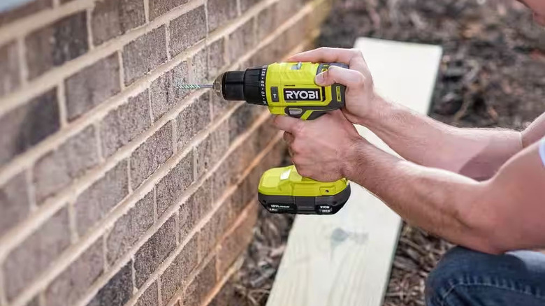 Ryobi ONE+ 18V Cordless 1/2 in. Hammer Drill drilling into a brick wall