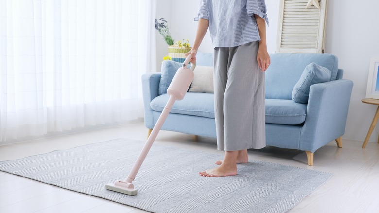 person vacuuming rug