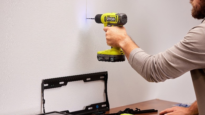 person drilling into drywall