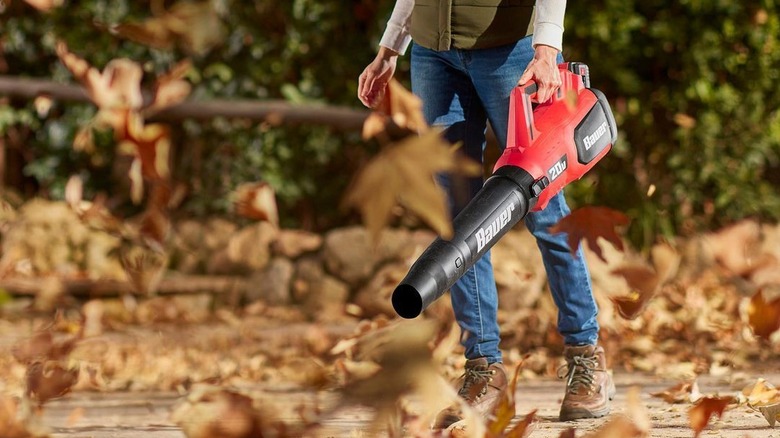 Woman using Bauer blower on leaves