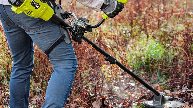 Person using Ryobi string trrimmer