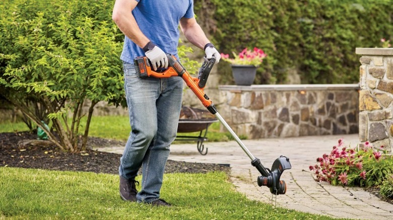 Person using Black+Decker string edger