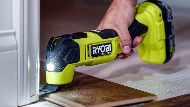 Person using Ryobi oscillating tool on trim