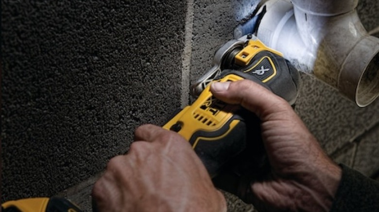 Person using DeWalt oscillating tool on PVC