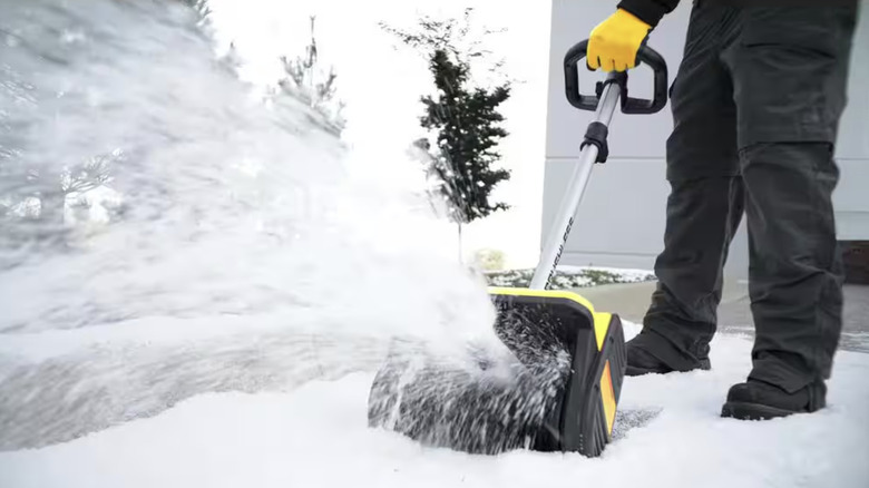 Person using an electric snow shovel to clear snow