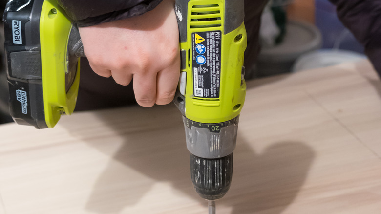 person using ryobi drill