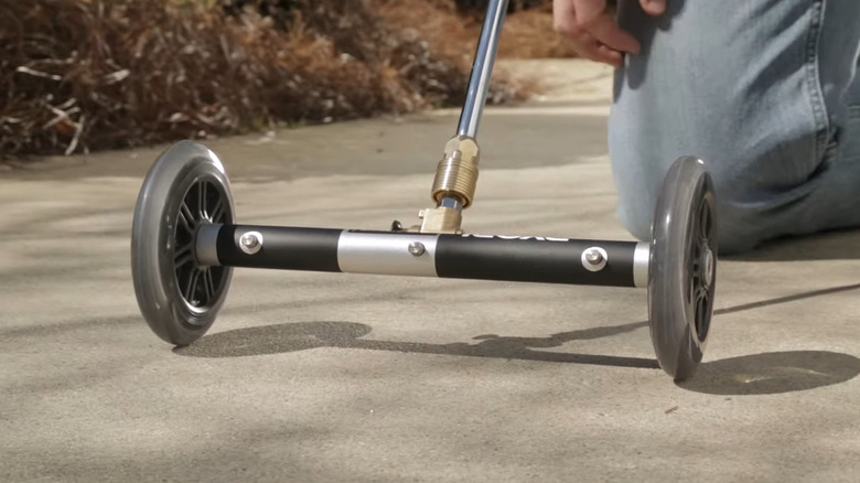 Water broom next to person's knee