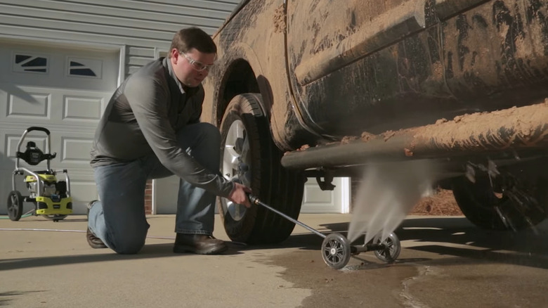 Person cleaning under car