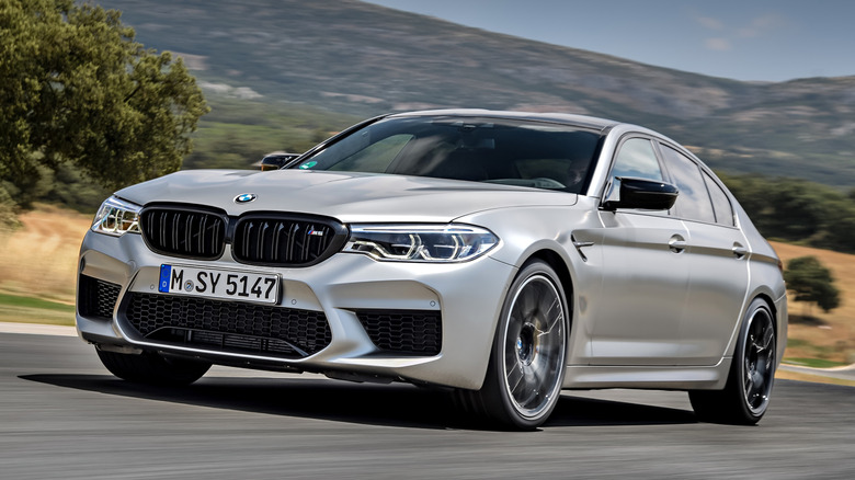 Front 3/4 view of 2018 BMW M5 Competition driving on road