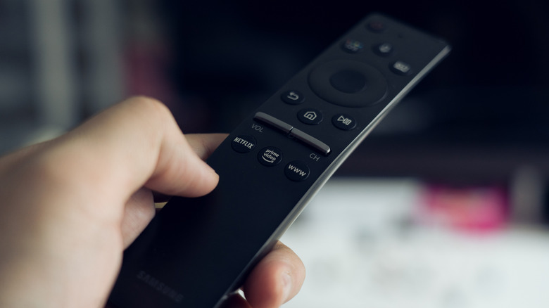 Woman's hand using holding a Samsung TV remote