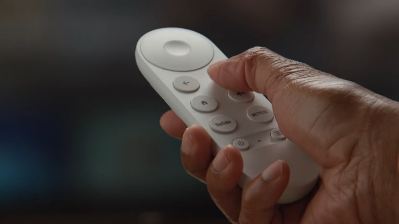 A hand holding a Chromecast Remote