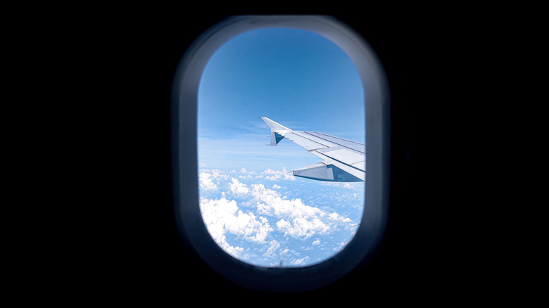 Looking out the window of an airplane and seeing the plane's wing