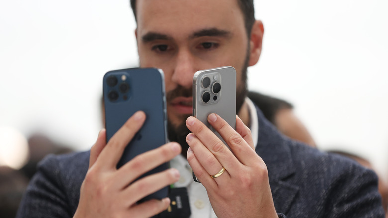 man holding two iPhone 15 Pros