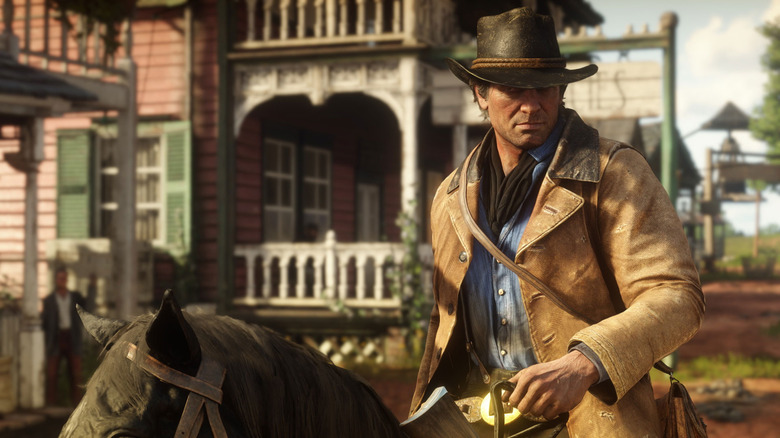 Arthur Morgan riding on the back of a black horse in Red Dead Redemption 2.