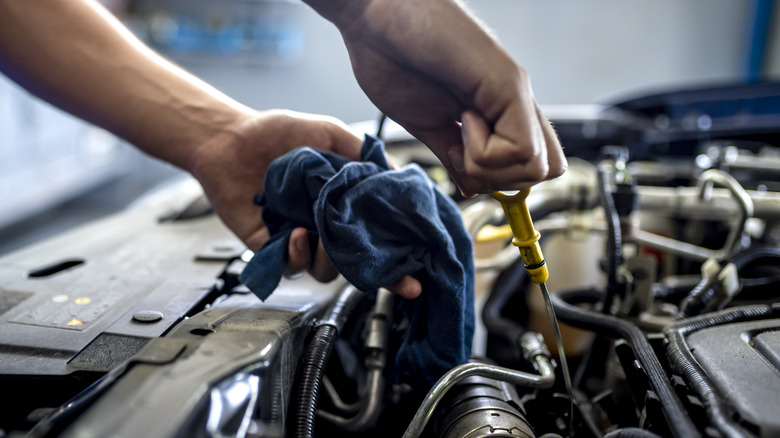 Mechanic checking oil level with dipstick