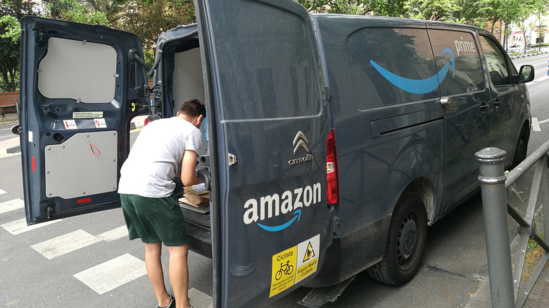 A person outside an Amazon delivery vehicle