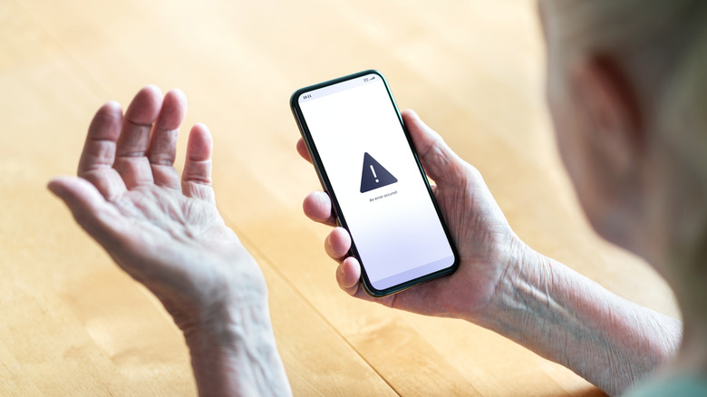 A person looking at a phone displaying an error message.