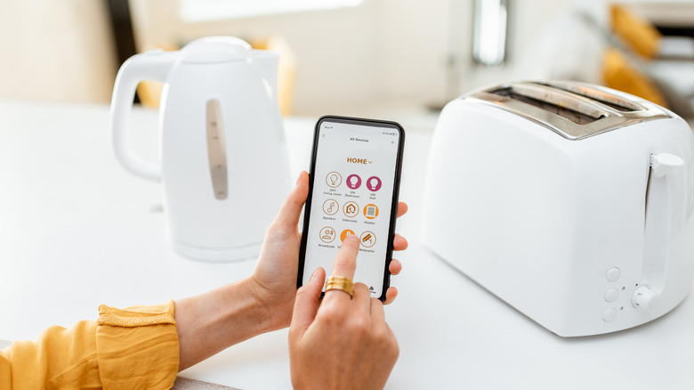 A phone being used to activate a smart toaster.