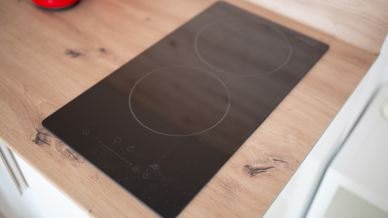 A smart induction cooktop on a wood counter.