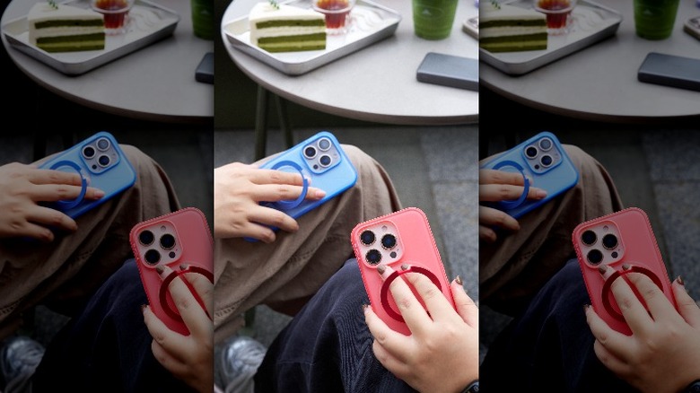 Two people holding the ring on their Ostand Spin cases.