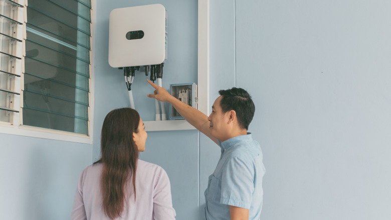 couple checking solar inverter