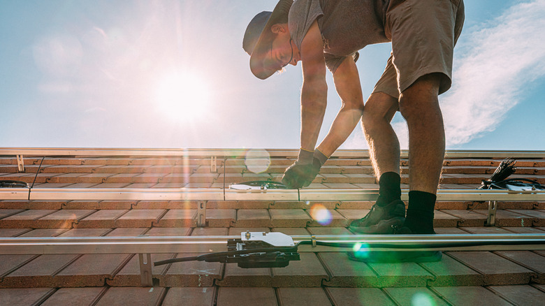 man installing solar panel roof