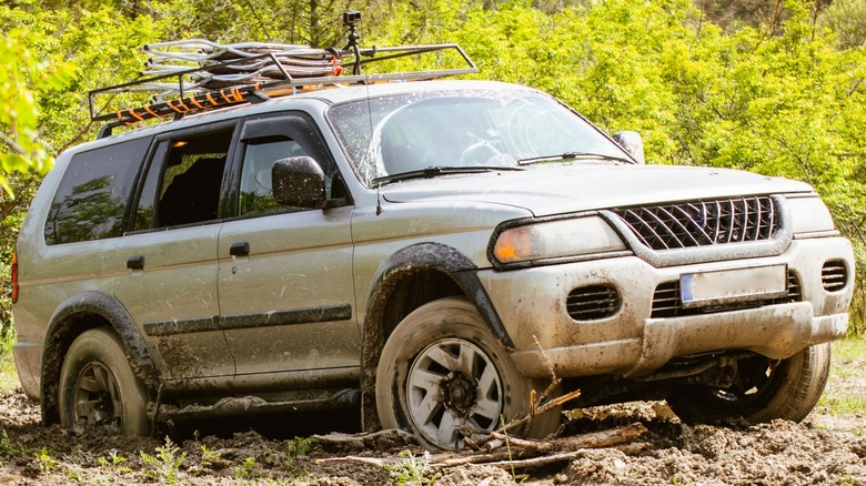 gray SUV driving in mud