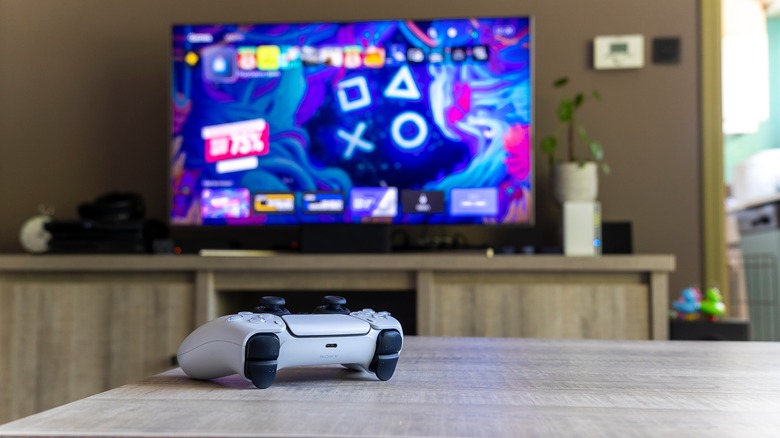 DualSense controller on table with PS5 TV UI in background