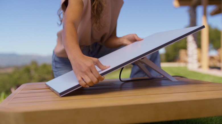 Woman setting down Starlink Standard dish