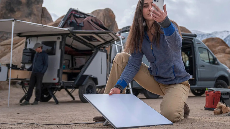 Woman trying to connect Starlink at camp site