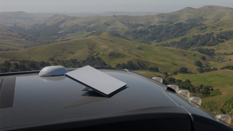 Starlink dish on the roof of a vehicle with mountains in the background