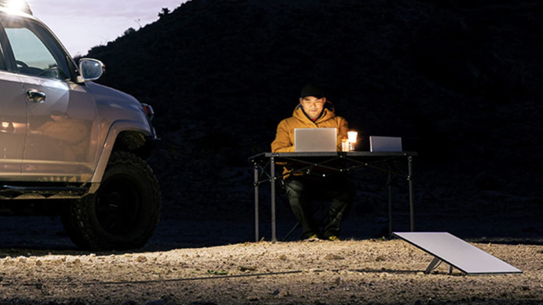 Man on laptop outside with Starlink in front of him