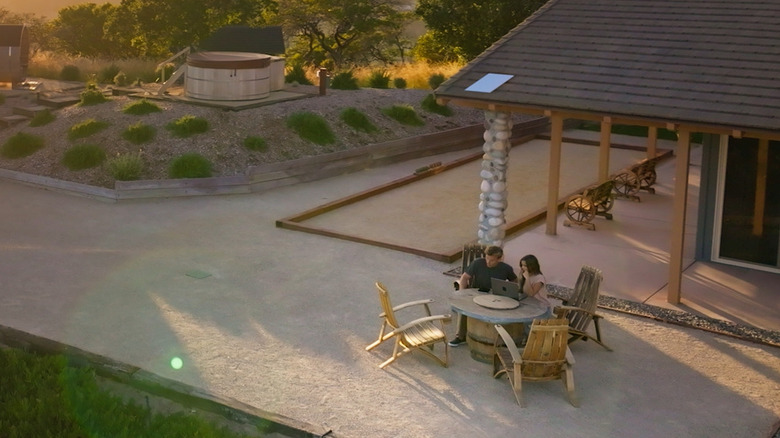 Couple using laptop outdoors with Starlink Standard on the roof