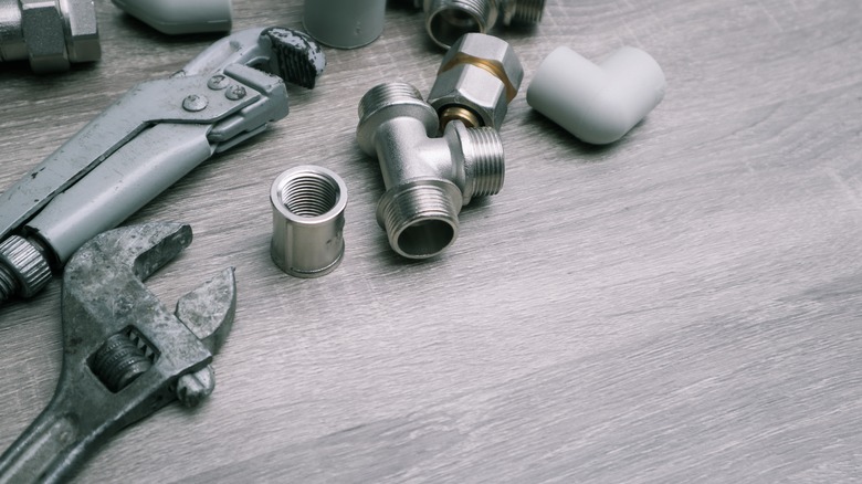 Plumbing tools on light wood floor