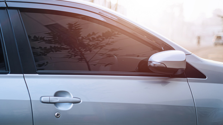 A car window with tint applied backed by a sunset