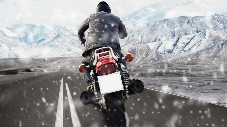 A man riding a motorcycle in a winter storm