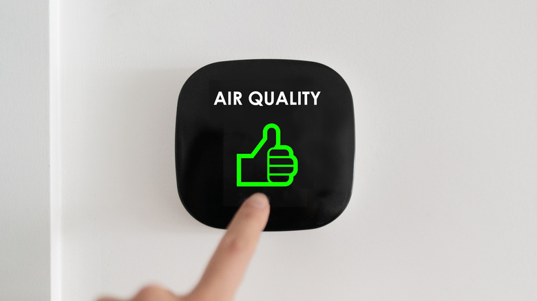 Finger on air quality button