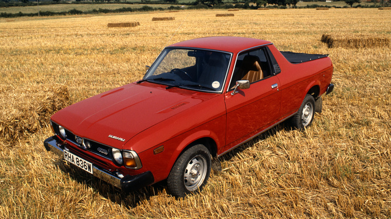 Red Subaru BRAT parked in a field