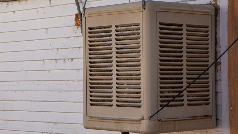 Evaporative swamp cooler mounted outside a home